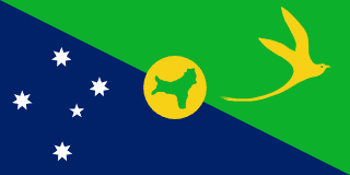 The flag of Christmas Island is divided diagonally from upper hoist side to lower fly side. The upper triangle is green with a yellow image of a Golden Bosun Bird. The lower triangle is blue with the Southern Cross constellation. A centered yellow disk displays a green map of the country.