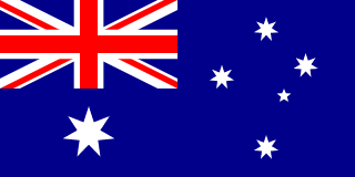 The flag of Heard Island and McDonald Islands has a dark blue field. It features the flag of the United Kingdom — the Union Jack — in the canton, beneath which is a large white seven-pointed star. A representation of the Southern Cross constellation, made up of one small five-pointed and four larger seven-pointed white stars, is situated on the fly side of the field.